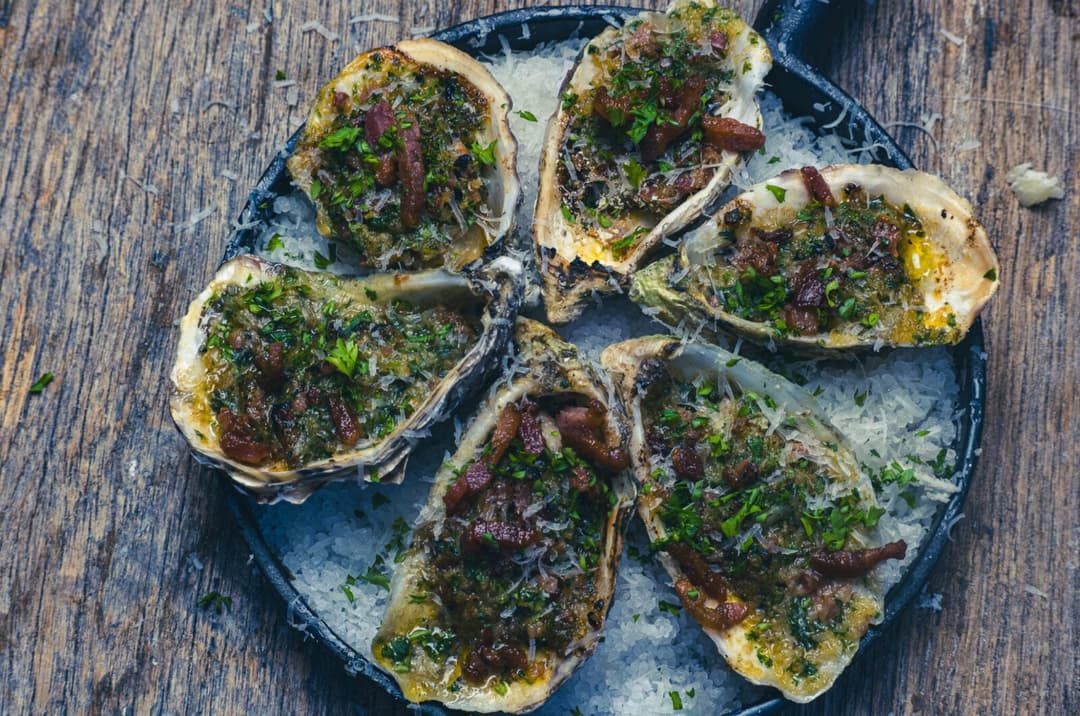 Flambierte Austern mit ausgebratenem Speck und Parmesan